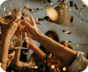 People raise their champagne glasses for a toast in a fun party atmosphere.