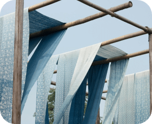 Blue and white fabrics fluttering from outdoor wooden clotheslines