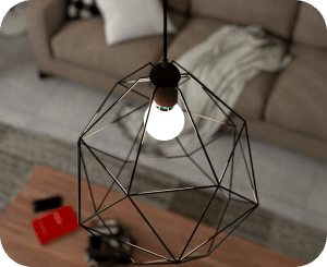 A pendant light hangs above a wooden table, with a beige couch in the background.